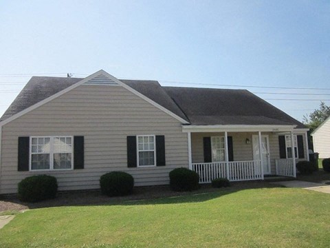 a white house with a porch and a lawn