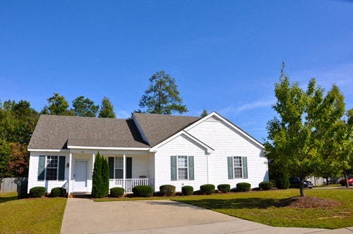 a white house with a gray roof and a driveway