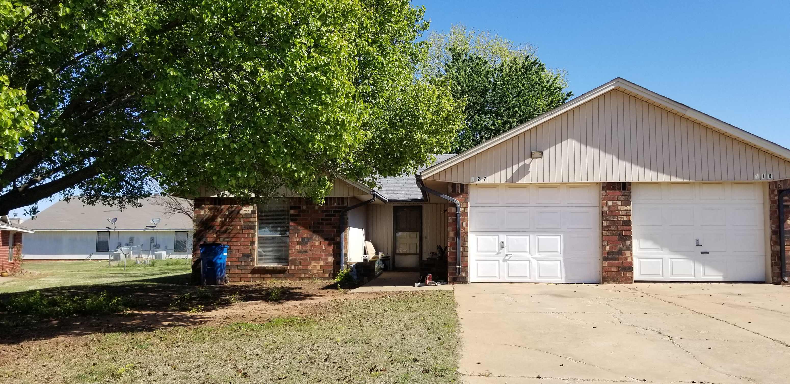 a house with a white garage door and a tree