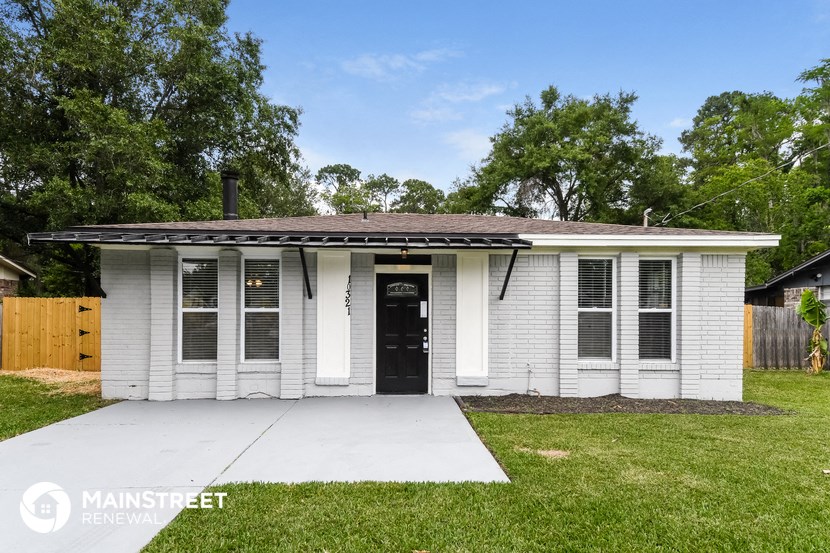 a small white house with a porch and a driveway