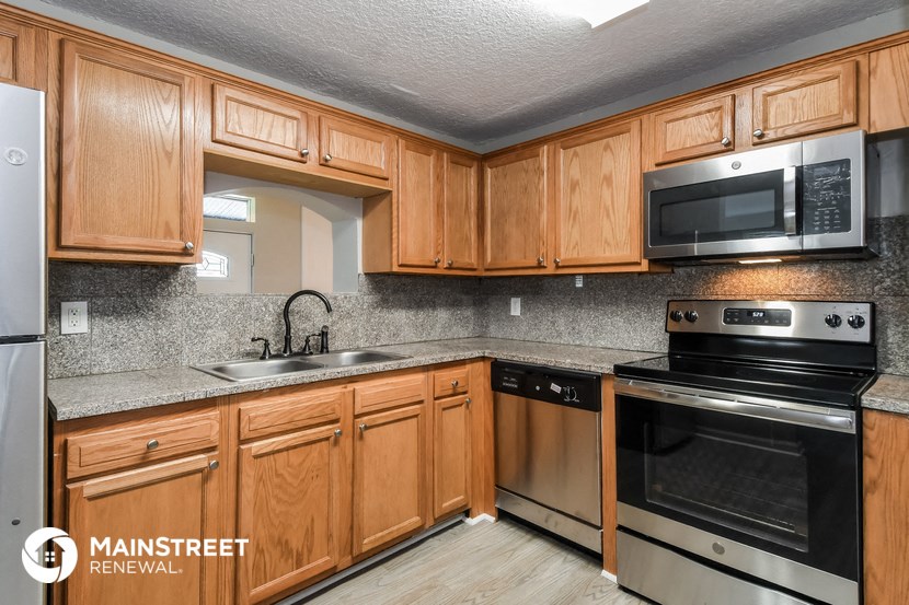 a kitchen with wooden cabinets and stainless steel appliances
