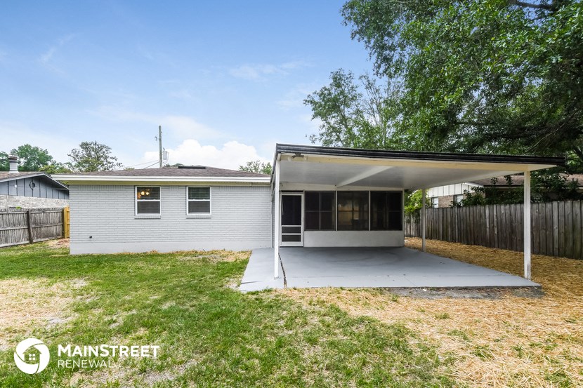 a small white house with a garage and a yard