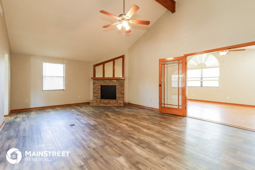 the living room of an empty house with a fireplace