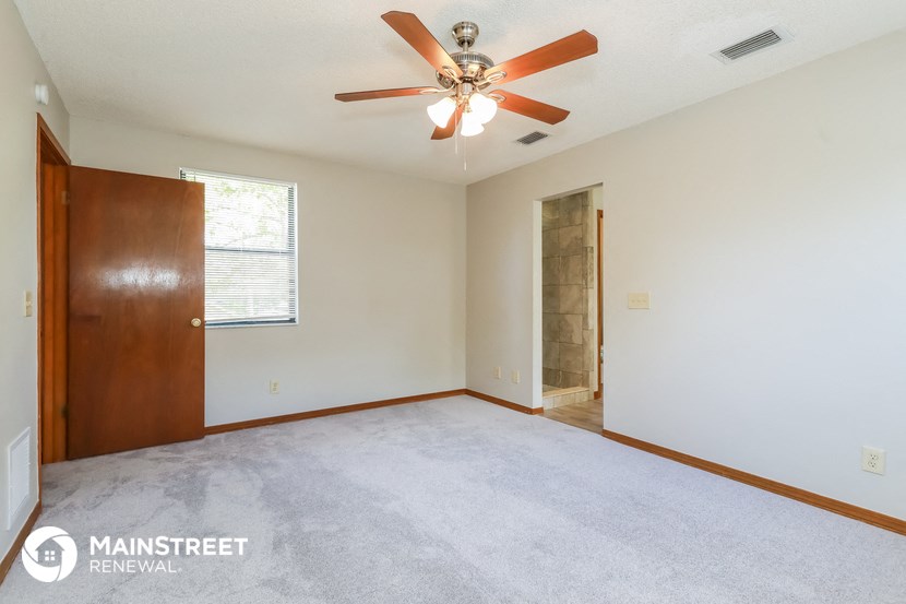 the living room of an empty house with a ceiling fan