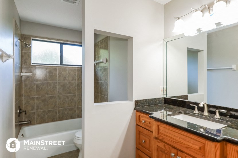 a bathroom with a sink and a mirror and a shower and a toilet