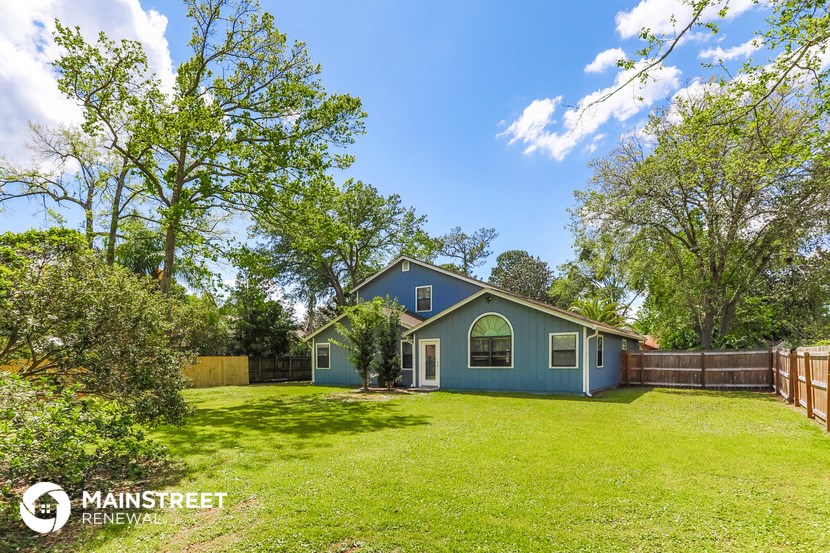 a blue house with a yard and a fence