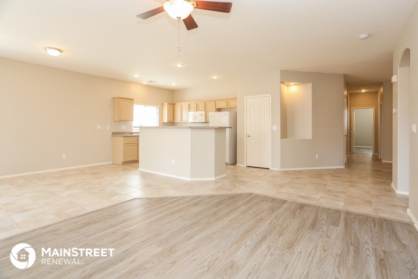 an open kitchen and living room with a ceiling fan