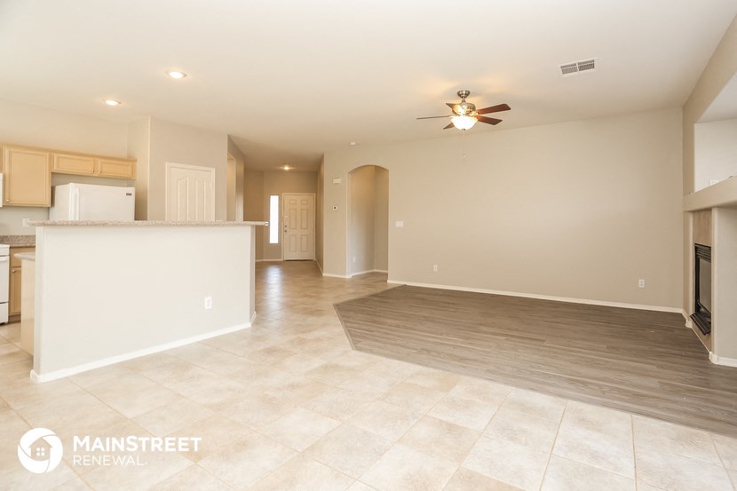 an open kitchen and living room with a ceiling fan