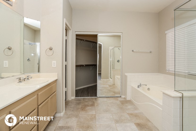 a bathroom with a tub and a sink and a mirror