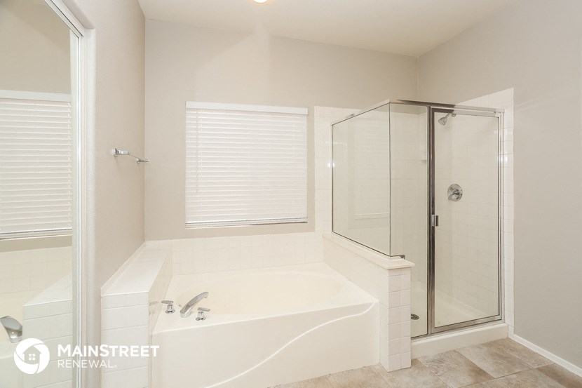 a white bathroom with a tub and a shower