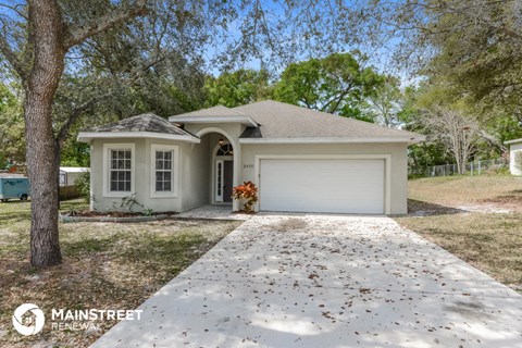 a white house with a driveway and a garage door