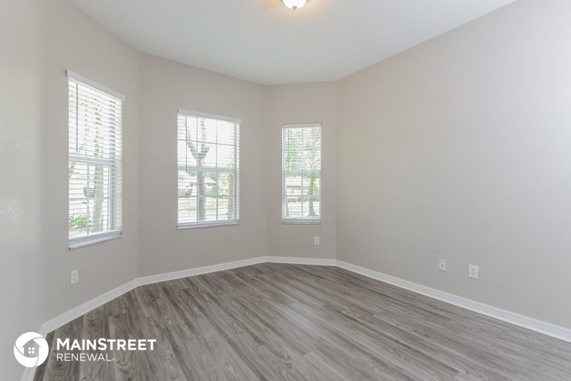 the living room of a new home with wood flooring and windows