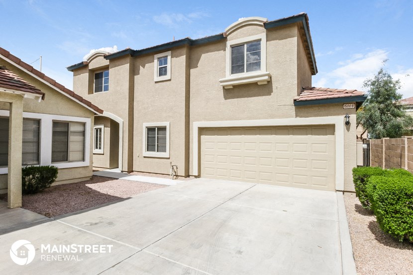 a beige house with a driveway and a garage door