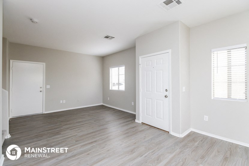 the living room of a new home with white walls and wood flooring