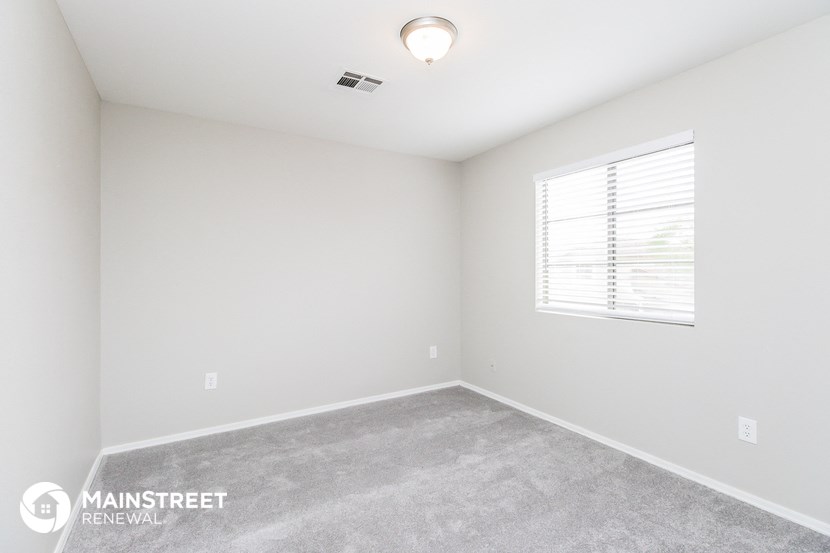 a bedroom with a carpeted floor and a window