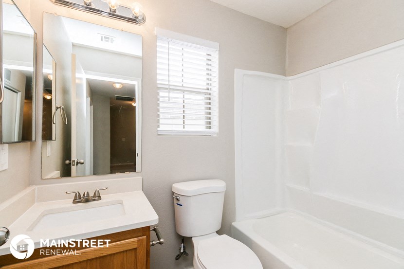 a bathroom with a sink toilet and a mirror and a tub