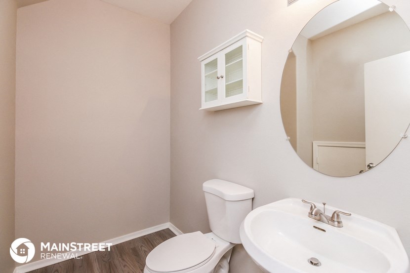 a bathroom with a sink toilet and a mirror