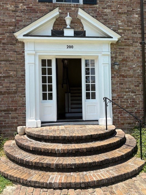 A white door with a black handle is on a brick building.