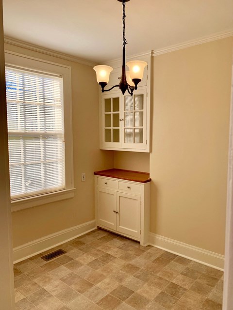 a small kitchen with a white cabinet and a window