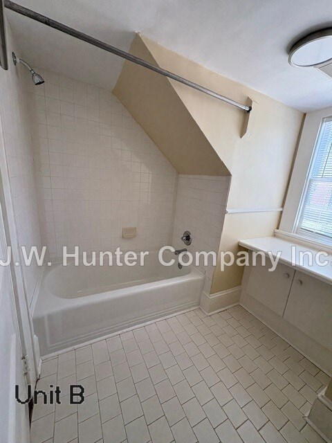 A bathroom with a tub and a window.