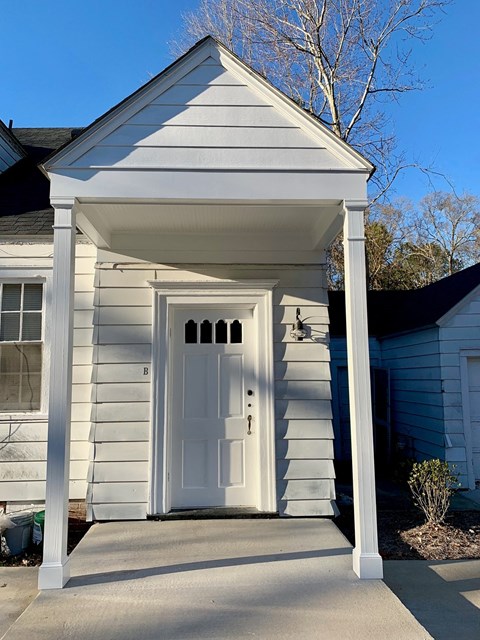 A white door is on the front of a house.