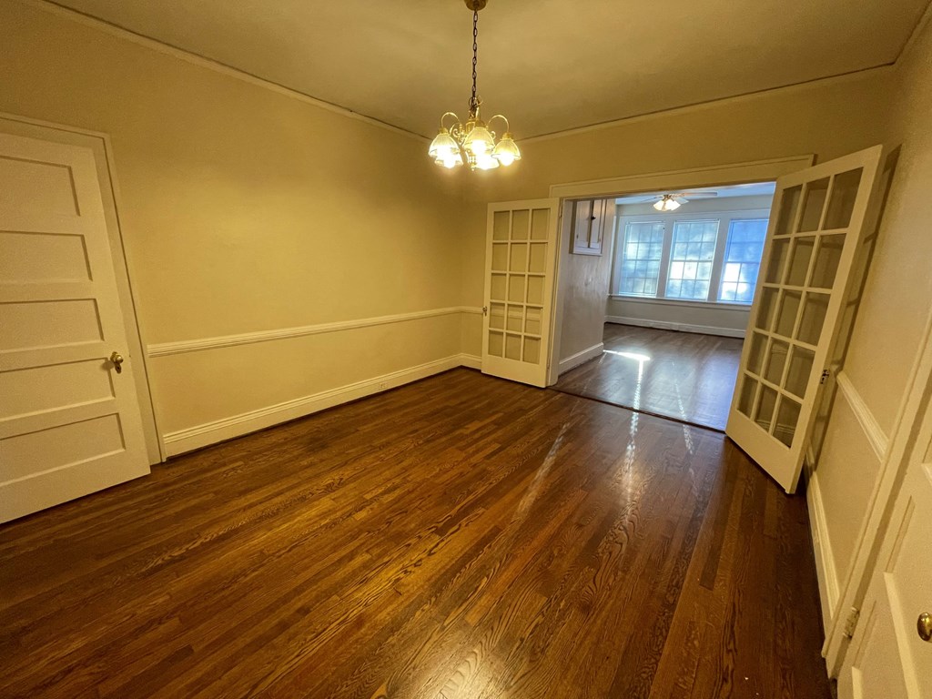 A room with wooden floors and a chandelier.