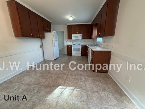 A kitchen area with brown cabinets and a white refrigerator.
