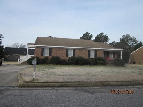 a brick house on the side of a street