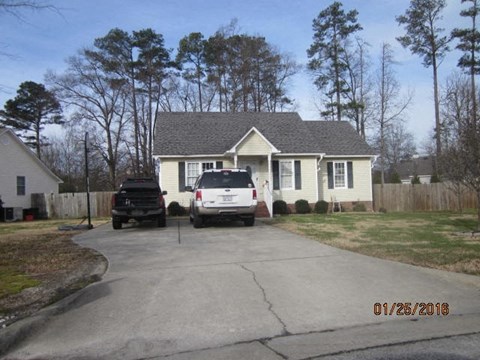 A house with a car parked in front of it.