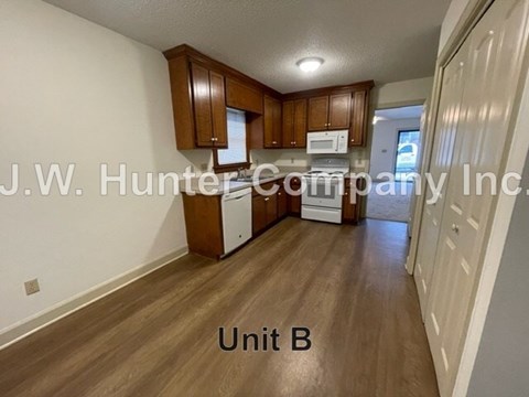 A kitchen area with wooden cabinets and a microwave.