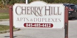 A sign for Cherry Hill APTS & Duplexes with a phone number.