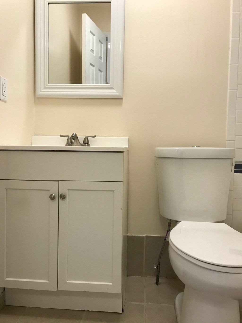 A white toilet sits next to a sink in a bathroom.