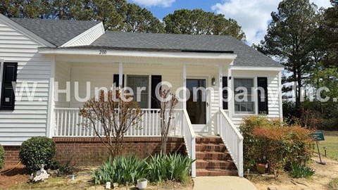 A white house with a porch and a sign that says "Hunterdon".