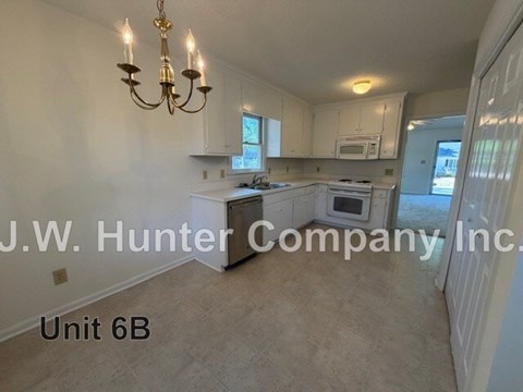 A kitchen with a chandelier and a sign that says J.W. Hunter Company Inc.