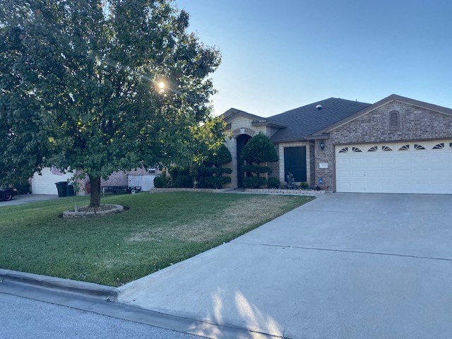 a house with a driveway and a tree in front of it