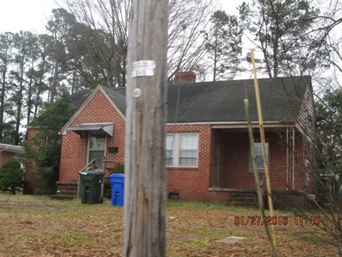 a brick house with a wooden pole in front of it