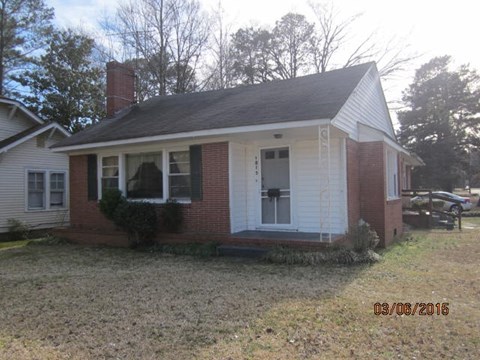 A small house with a red brick exterior and a white door.