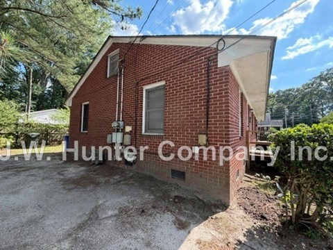 A red brick building with a white sign that reads "J.W. Hunter Company Inc." in front of it.