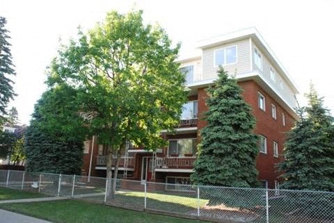 an apartment building with a fence in front of it
