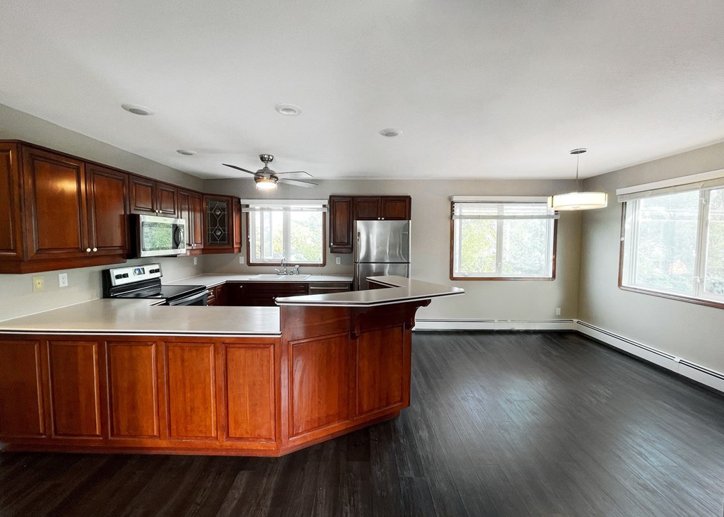 an empty kitchen with wooden cabinets and a counter top