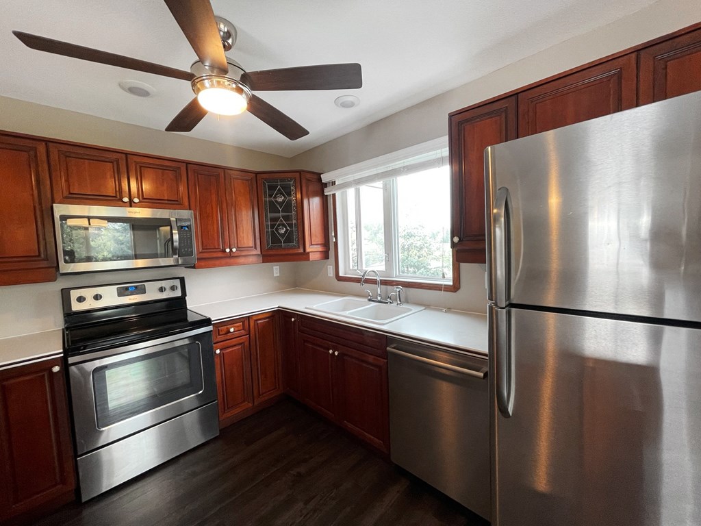 a kitchen with stainless steel appliances and a ceiling fan
