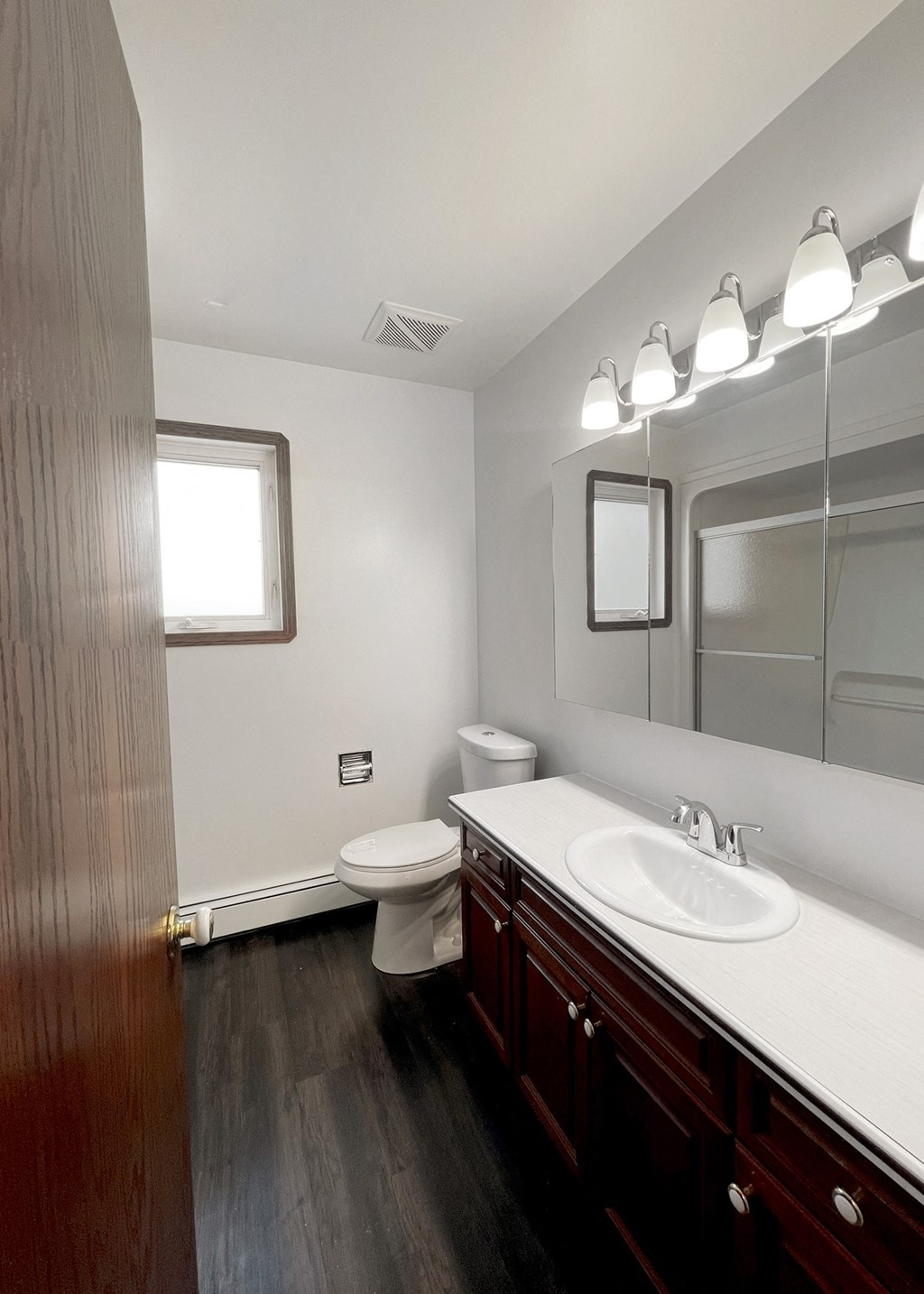 an empty bathroom with a sink toilet and mirror