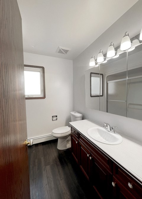 an empty bathroom with a sink toilet and mirror