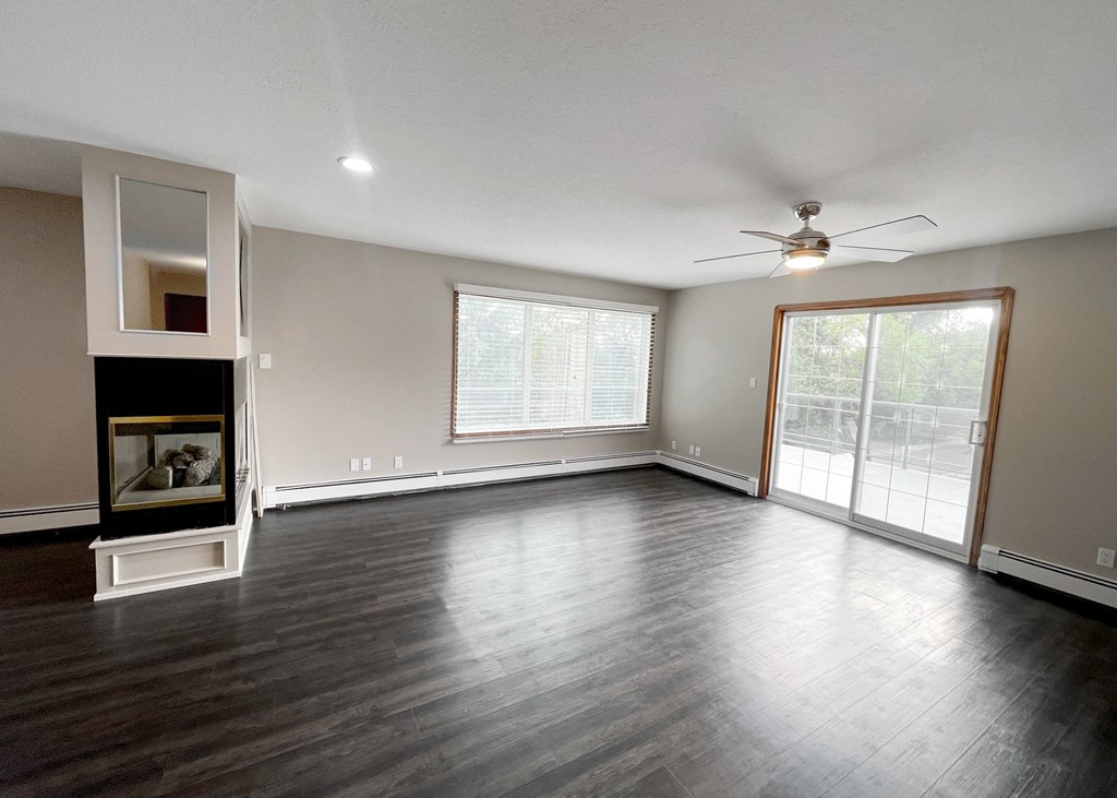 an empty living room with wood floors and a fireplace