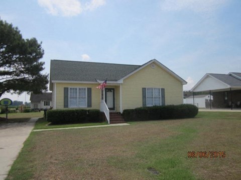 a yellow house with a flag on the front