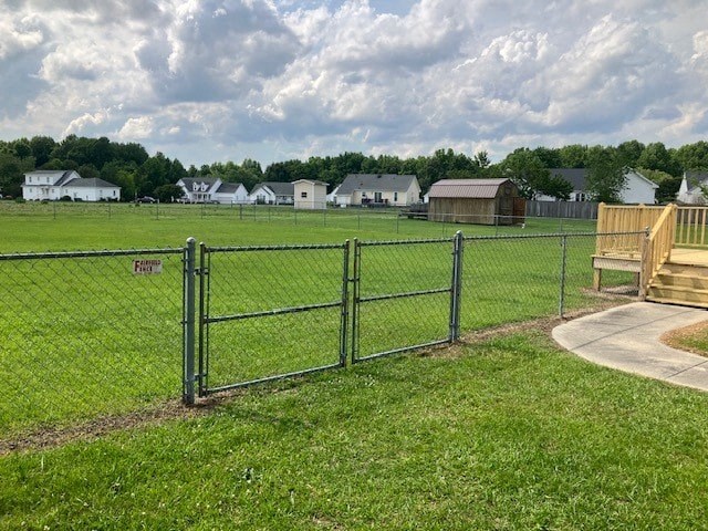 a park with a wooden bench in front of a fence