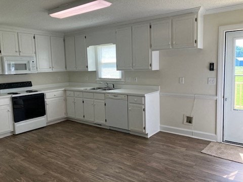 a kitchen with white cabinets and a stove and a sink