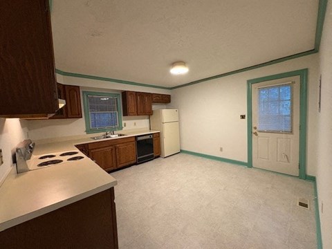A kitchen with a white counter top and wooden cabinets.