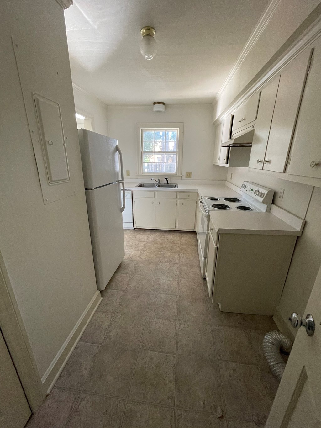 an empty kitchen with white appliances and white cabinets
