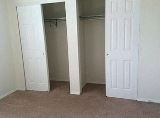 an empty bedroom with a closet and two doors